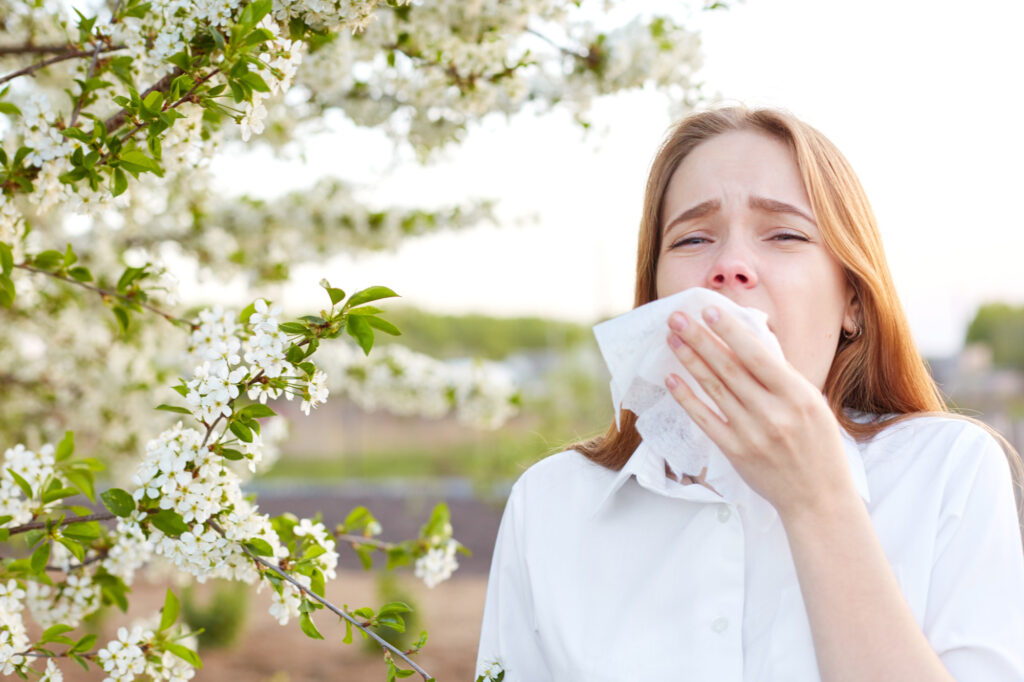 woman with allergies covering a sneeze